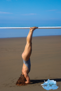 Woman doing headstand on the beach