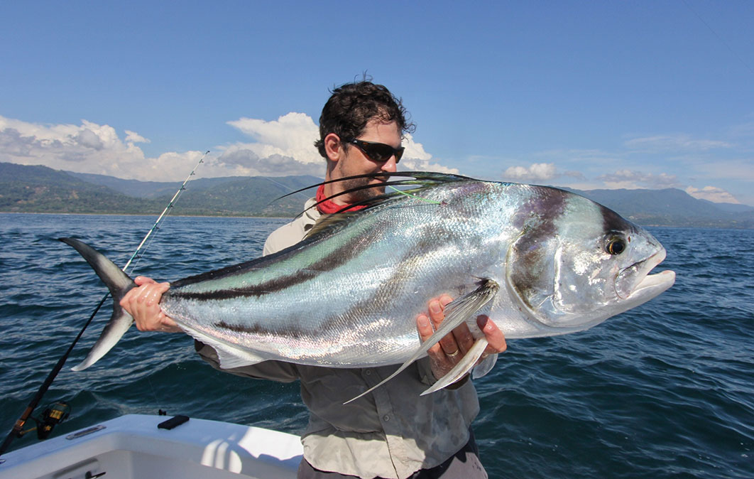 Man holding large rooster fish