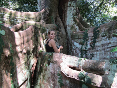 Woman standing at base of a huge tree