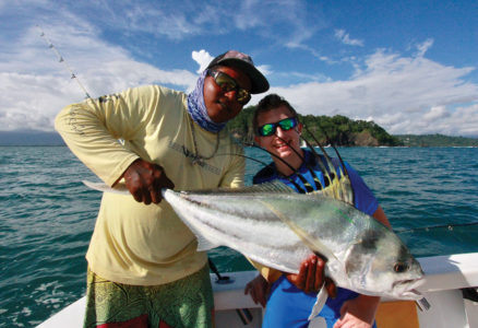 Man and boy holding roosterfish