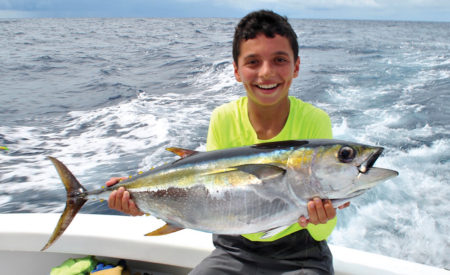 Boy holding a tuna