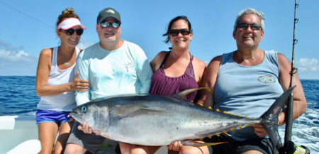 Group holding a large tuna