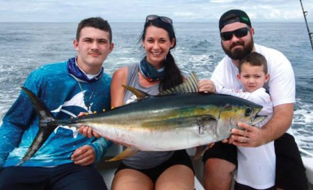 Family holding a tuna