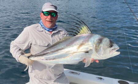 man holding a roosterfish